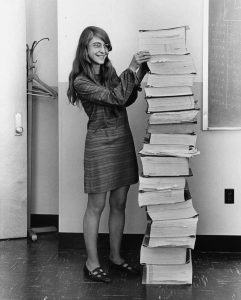 Margaret Hamilton standing next to the AGC's code