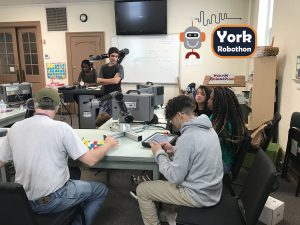 A York Robothon team works with their client, Christian, who is a local artist that wants to use a robot to help create art